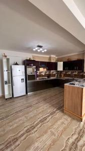 an empty room with a kitchen with a refrigerator at YEMMA GOURAYA LOFT in Bejaïa