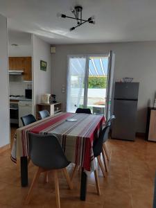 una cucina con tavolo e sedie in una stanza di MaMaMé a Les Sables-dʼOlonne