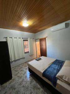 a bedroom with a bed and a flat screen tv at Casa Iguaçu in Foz do Iguaçu
