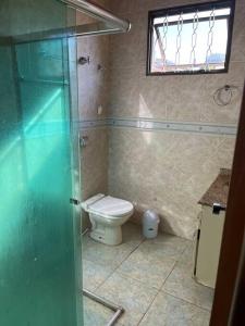 a bathroom with a toilet and a glass shower at Casa Iguaçu in Foz do Iguaçu +6 photos