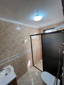 a bathroom with a shower and a toilet and a sink at Casa Iguaçu in Foz do Iguaçu