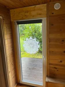 - une porte ouverte menant à une terrasse couverte dans une cabane en bois dans l'établissement Chatka pod lasem, à Jarnołtówek