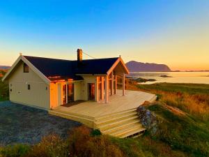 a house on the beach with a deck at Sunset Panorama - Superior Cabin Lofoten in Sand