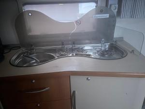 un lavandino da cucina con specchio sopra di Asuntovaunu 2:lle a Helsinki