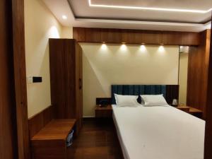 a bedroom with a large bed with white sheets at HOTEL B S HEIGHTS in Deoghar