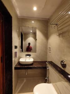 Un baño con lavabo, inodoro y espejo. en HOTEL B S HEIGHTS, en Deoghar