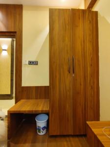 a large wooden cabinet in a room with a bucket at HOTEL B S HEIGHTS in Deoghar