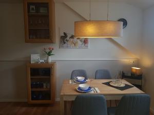a dining room table with blue chairs and a light fixture at Ferienwohnung Wohlleben Gbr in Simmerath