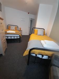 duas camas num quarto com amarelo e branco em Flat 5 Corner House 1 bedroom em Doncaster