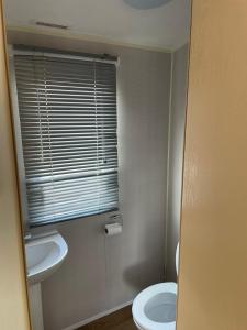 a bathroom with a sink and a toilet and a window at The Breakaway in Rochester