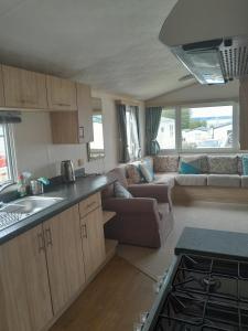 a kitchen and living room of a caravan with a couch at The Breakaway in Rochester