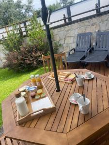 una mesa de madera con comida y bebida en el patio en Quintinha da Cachadinha, en Ponte de Lima