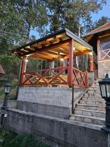 a wooden pavilion with stairs in a park at Divcibarski Konak in Divčibare