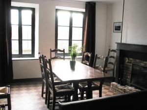 a dining room with a table and a fireplace at Ferme Des Chapelles in Fresnes-en-Tardenois