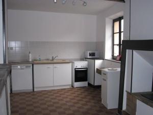 una cocina con armarios blancos y electrodomésticos blancos en Ferme Des Chapelles, en Fresnes-en-Tardenois