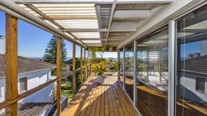 an open deck with a view of a house at Anchor Bay Workation in Cape Town