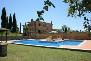 a swimming pool in front of a house at Villa Fosca in Lucignano