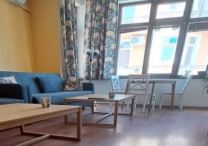 a living room with a couch and tables and chairs at Ivory Tower Hostel in Sofia