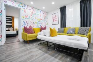 a living room with a couch and a yellow couch at Vacay Spot Wynwood Deco 2 Kitchens Shower Massage jets, BBQ, Patio LED vibes, Prime LOC! 6 blocks away from Bars, Nite Clubs, Res, Shops in Miami