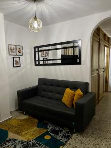un sofá negro sentado en una sala de estar en Hermoso apartamento en zona central de Medellín, en Medellín