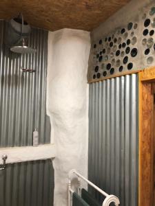 a bathroom with a shower with a white wall at Rabbits 1or 2 bedroom hobbit style hillset earthen dartmoor eco home in South Brent +31 photos
