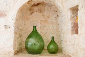 two green vases sitting on a shelf in a wall at Villa Mina in Ostuni