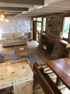 a living room with a couch and a fireplace at Rabbits 1or 2 bedroom hobbit style hillset earthen dartmoor eco home in South Brent