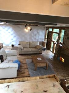 a living room with two couches and a fireplace at Rabbits 1or 2 bedroom hobbit style hillset earthen dartmoor eco home in South Brent