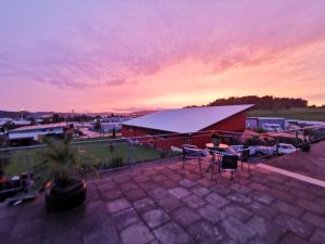 a sunset over a patio with a table and chairs at Ferienwohnung mit Garten und terasse Münsingen in Münsingen