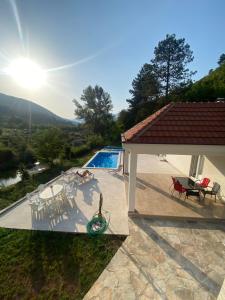 a patio with a table and chairs and a pool at Vila Oaza in Trebinje