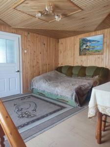 Bett in einem hölzernen Zimmer mit einer Decke in der Unterkunft Borgaza in Jaremtsche