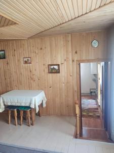 ein Esszimmer mit einem Tisch und einer Holzwand in der Unterkunft Borgaza in Jaremtsche