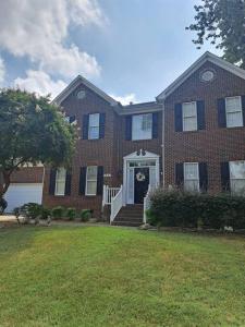 a large brick house with a front door and a yard at Chiky Sanctuary in Raleigh