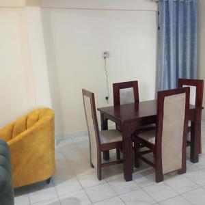 a dining room with a wooden table and chairs at Milly's homes in Kakamega