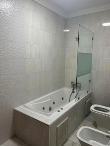 uma casa de banho branca com uma banheira e um WC em Recidence montblanc Tanger em Tânger