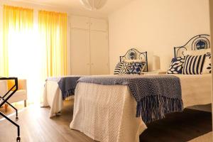two beds in a room with blue and white pillows at Cozy&Charming Naz in Nazaré