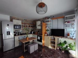 een keuken met een witte koelkast en een tafel bij Appartement cosy in Perpignan