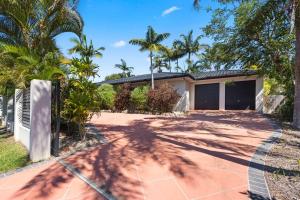 uma casa com palmeiras e uma entrada em 5 bedrooms with a pool em Kawungan