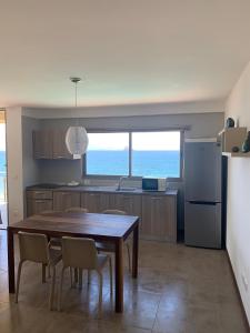 明德盧的住宿－Lazareto Oceanview，厨房配有桌椅和冰箱。