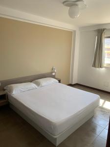 a white bed in a room with a window at Lazareto Oceanview in Mindelo