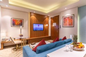 un soggiorno con 2 divani blu e una TV di Century Hotel Doha a Doha