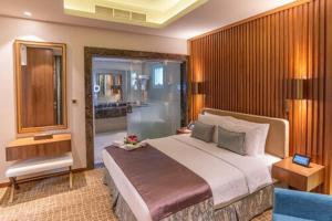 فندق سينشري الدوحه في الدوحة: غرفة نوم بسرير كبير ونافذة