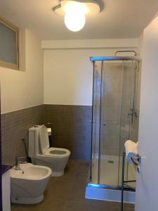 a bathroom with a toilet and a glass shower at Lazareto Oceanview in Mindelo