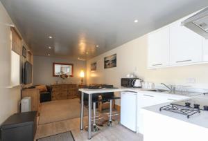 Wend Gardens, Carleton, Skipton. Pet friendly. في سكيبتون: مطبخ مع دواليب بيضاء وطاولة في الغرفة