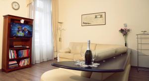 una sala de estar con sofá y una botella de vino en una mesa en Classic Central Apartment, en Budapest