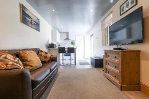 uma sala de estar com um sofá e uma televisão de ecrã plano em Wend Gardens, Carleton, Skipton. Pet friendly. em Skipton