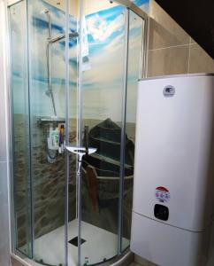 a shower in a room with a refrigerator at Le Sanctuaire in Missillac