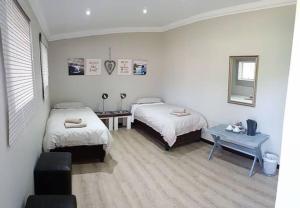 a bedroom with two beds and a table in it at The Water Wheel in Vryheid