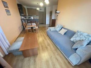 ステグナにあるSłoneczny Apartamentの青いソファとテーブルのあるリビングルーム