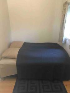ein kleines Schlafzimmer mit einem Bett mit einer blauen Decke in der Unterkunft Leilighet i Vadsø in Vadsø